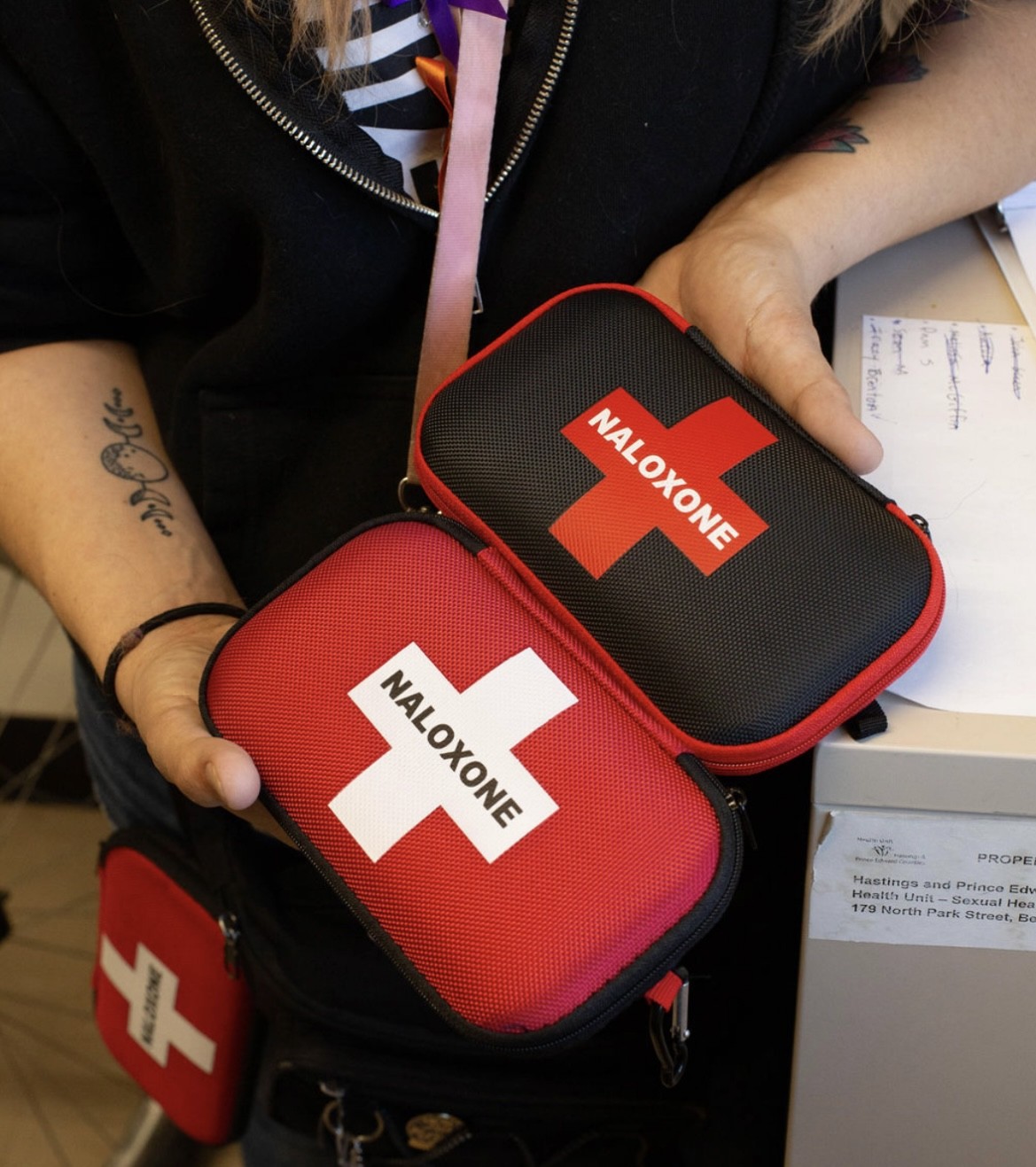 Hilary Thomas holds up two Naloxone kits. 